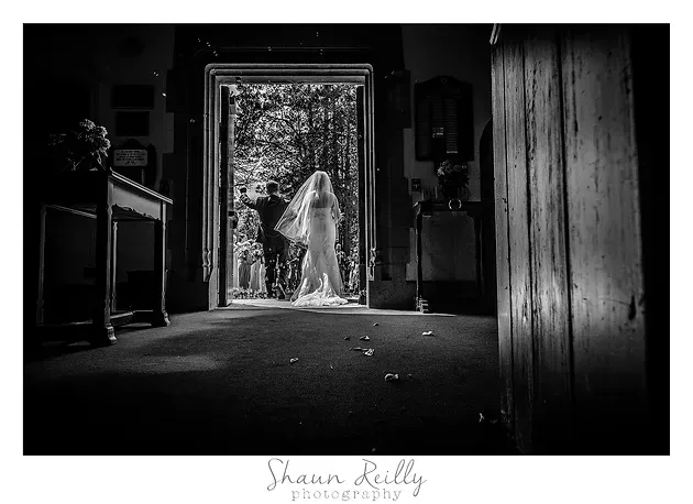 Ghostly figure in a doorway of a dark room, light streaming in behind it.