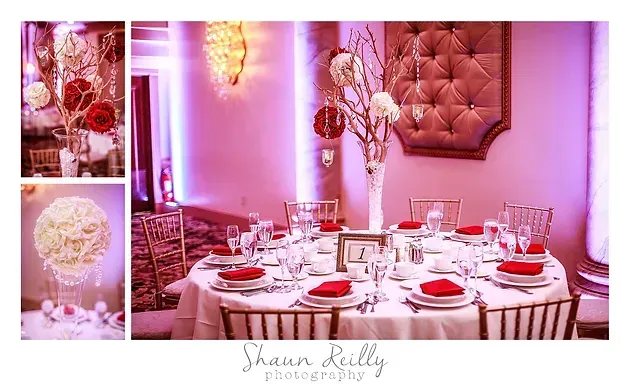 Pink-and-white decorated banquet table set with plates, glassware, and floral centerpieces in an elegant room