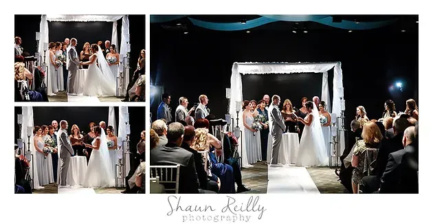 Wedding party posing and celebrating on a lit stage with a white arch backdrop