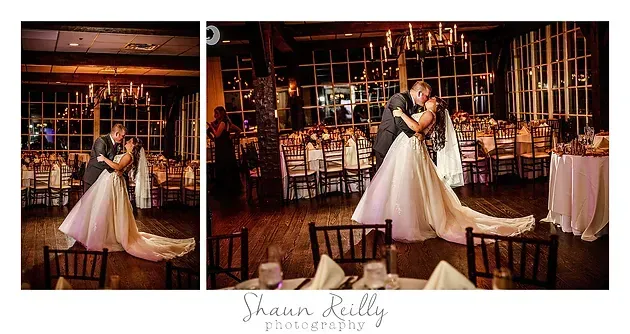 Bride and groom embrace during a wedding reception in a warmly lit rustic venue.