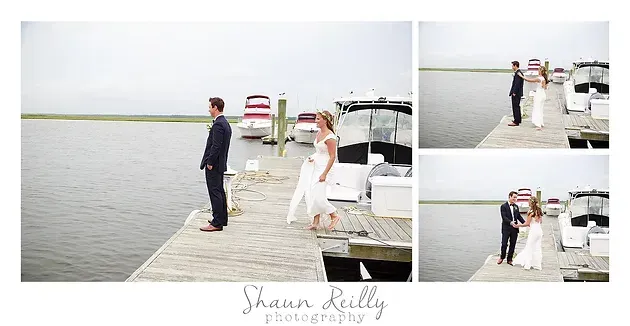 Wedding couple posing on a dock beside white boats on a calm lake