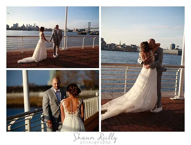 Wedding couple posing by the waterfront at sunset, bride in white gown and groom in gray suit