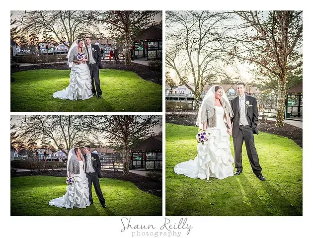 Wedding couple posing outdoors in a park, with bride in white gown and groom in gray suit.
