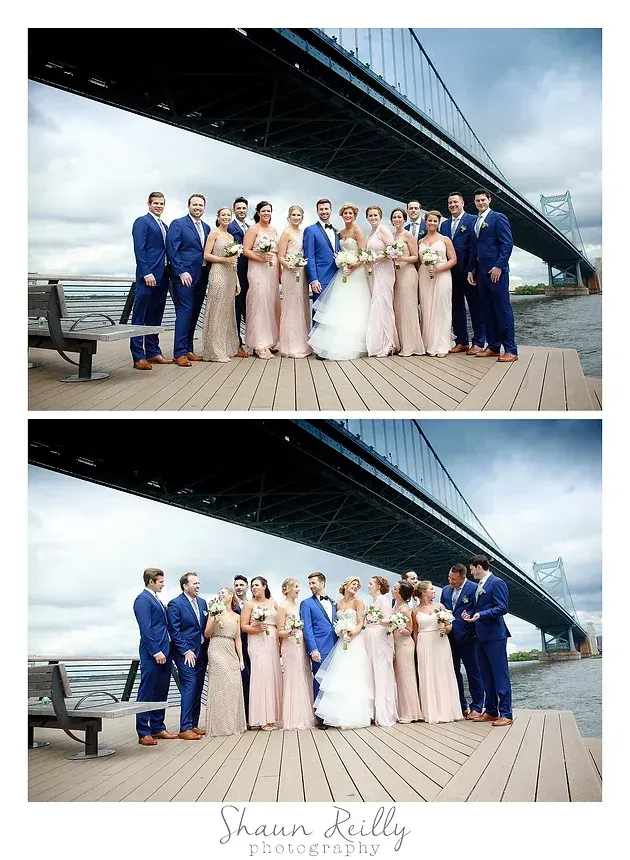 Wedding party posing beneath a bridge by the water, with one group in blue and blush formalwear