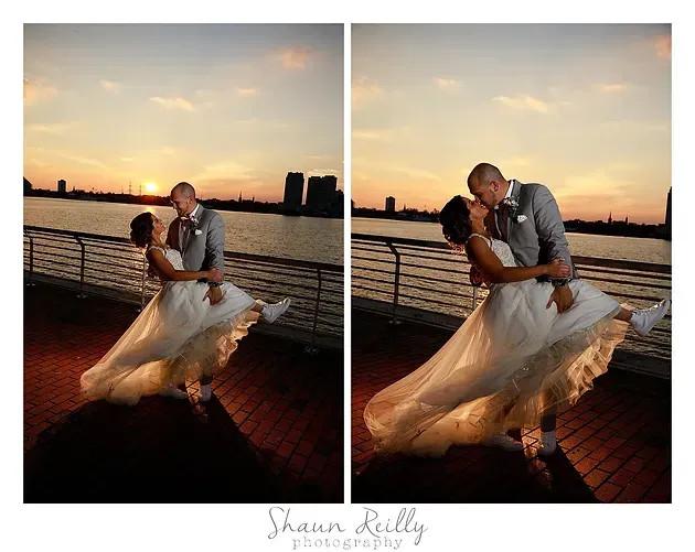 Couple embracing on a waterfront at sunset, bride's gown flowing as they kiss on a brick promenade.