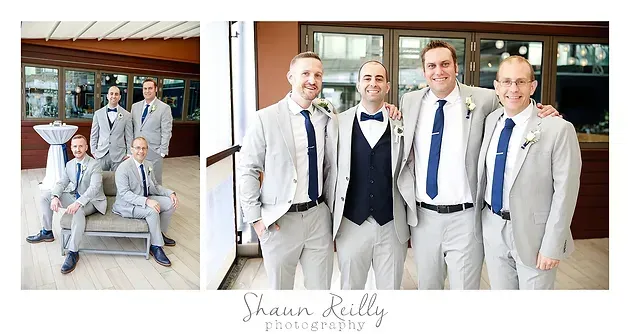 Five men in light gray suits and blue ties pose together in a bright indoor setting