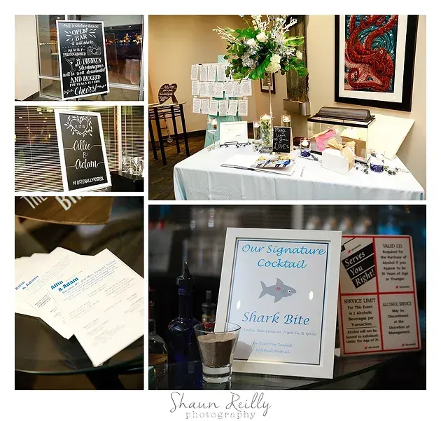 Wedding reception display table with guestbook, sign-in signs, framed art, and floral centerpiece