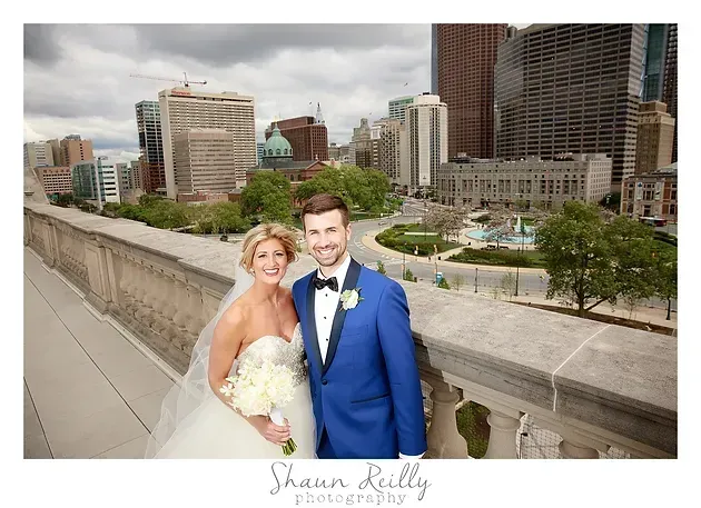 Bride and groom posing on a city rooftop with skyline in the background