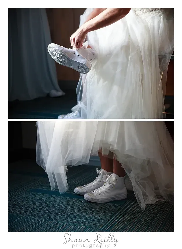 Bride in white dress adjusting a white sneaker beside a window, with a close-up of both shoes below