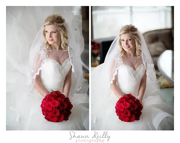Bride in white gown holding a bright red bouquet in a soft, indoor bridal portrait.