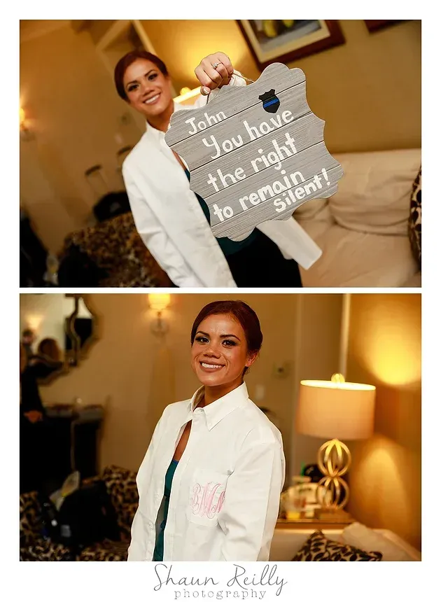 Bride in white jacket with wedding sign, posing indoors in a warmly lit room
