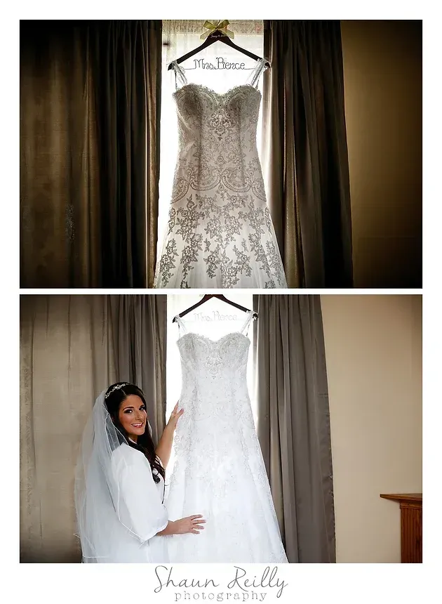 Wedding gown displayed on a hanger, with a bride holding the dress beside it in a fitting room.