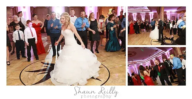 Bride dancing with guests at a lively wedding reception in a warmly lit ballroom