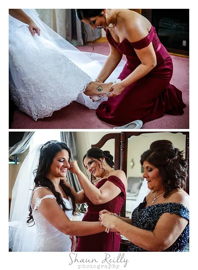 Bride receiving help with her shoe, with bridesmaids adjusting her dress and veil before the ceremony