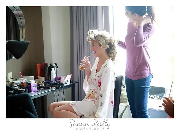 Woman getting hair and makeup done at a vanity before a photoshoot