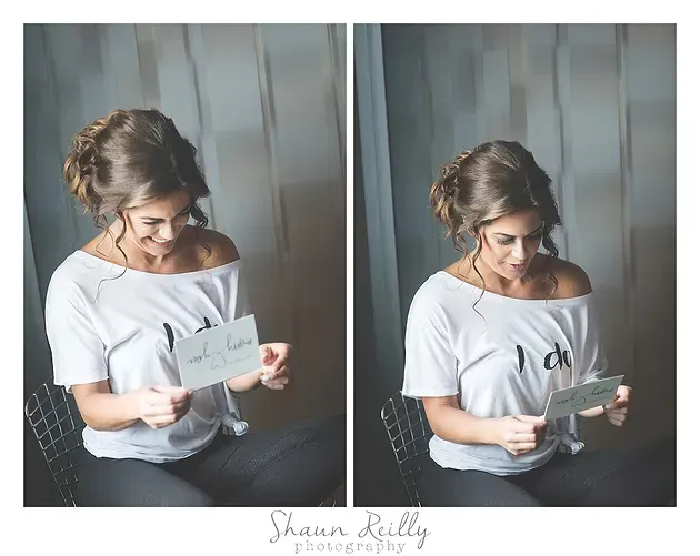 Woman in white top holding a card in a softly lit gray studio setting