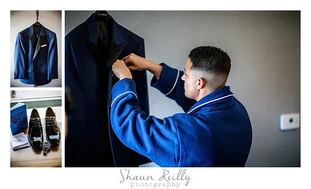 Man in blue robe adjusting a dark jacket while dress shoes and a shirt are arranged nearby