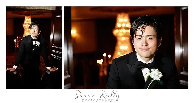 Formal portrait of a person in a black tuxedo with white boutonniere, posed indoors with warm bokeh lights