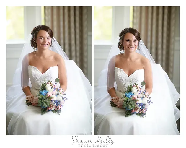 Bride in white gown and veil holding a colorful bouquet, seated by a window in a bright room.