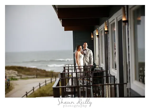 Couple standing on a seaside balcony overlooking the ocean