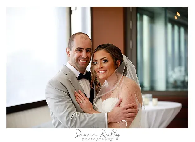 Smiling bride and groom posing together indoors at their wedding