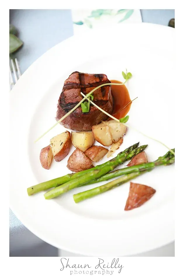 Plated steak with roasted potatoes and asparagus on a white dish