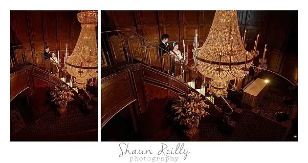 Warm chandelier-lit staircase with a person and floral arrangements in a grand interior scene