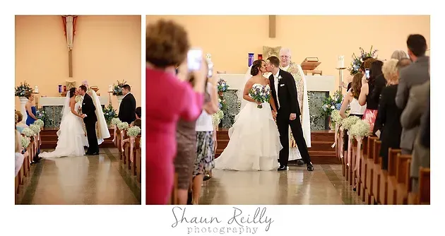 Bride and groom walk down chapel aisle as guests stand and applaud during wedding ceremony