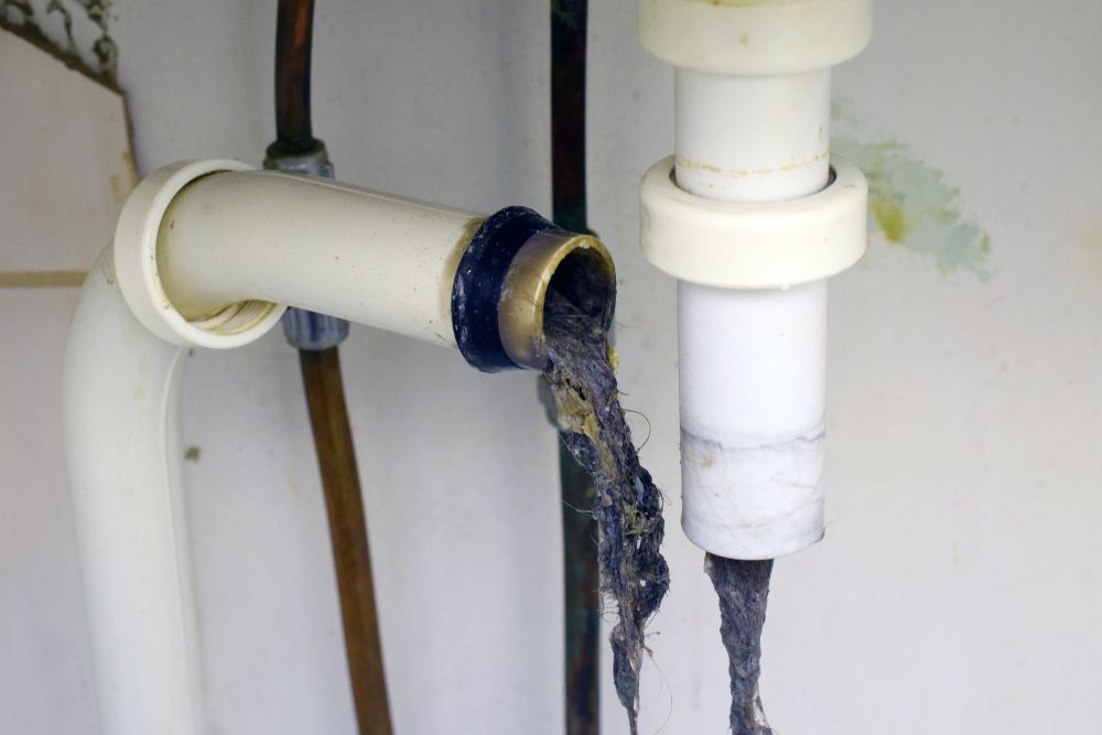 Plumbing Pipes With a Clogged Drain, Filled With Gray and Black Hair and Debris — Approved Plumbing Service in Woolner, NT