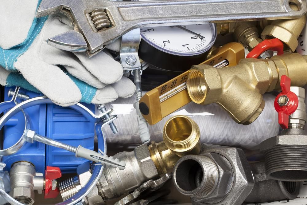 Wrench is Sitting on Top of a Pile of Plumbing Equipment — Approved Plumbing Service in Woolner, NT