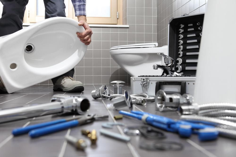 Plumber is Installing a Bidet in a Bathroom — Approved Plumbing Service in Burrum Heads, QLD