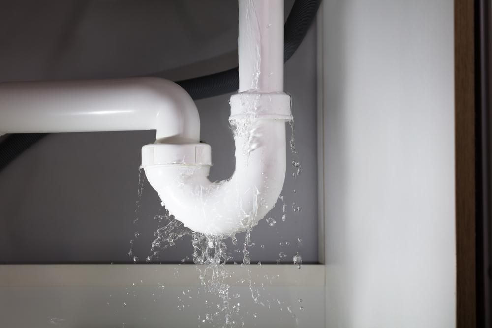 Sink Pipe is Leaking Water Under a Sink in a Bathroom — Approved Plumbing Service in Woolner, NT
