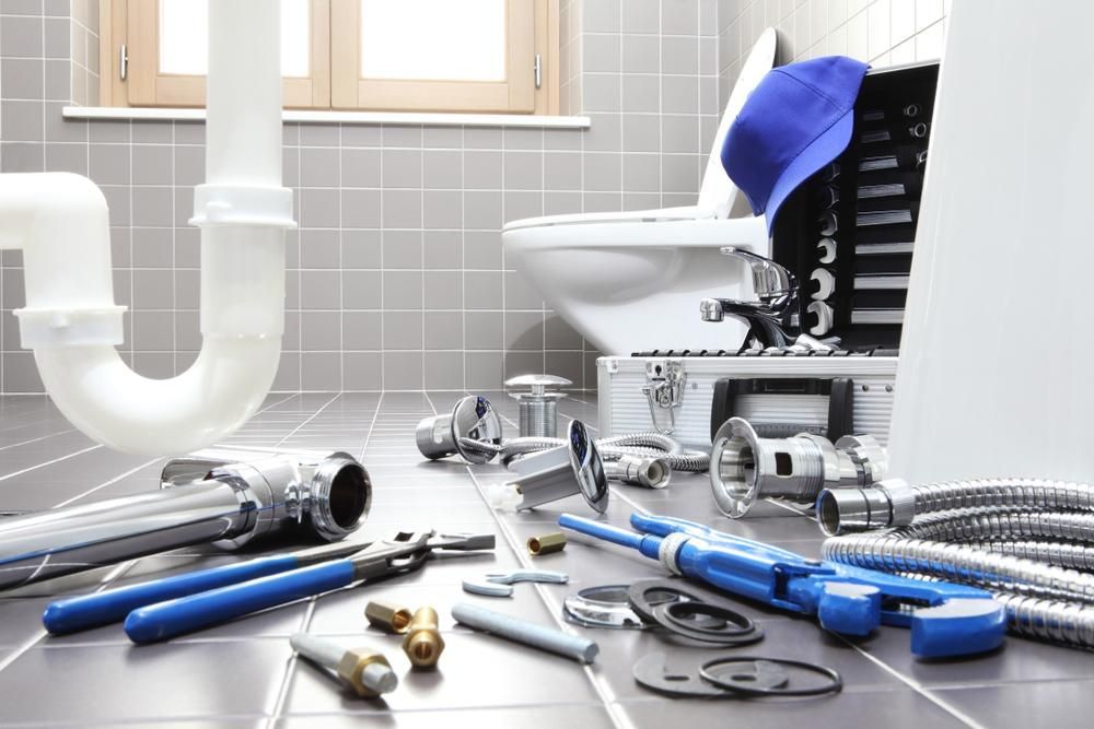 Bathroom With a Toilet, Sink, and Plumbing Tools on the Floor — Approved Plumbing Service in Woolner, NT