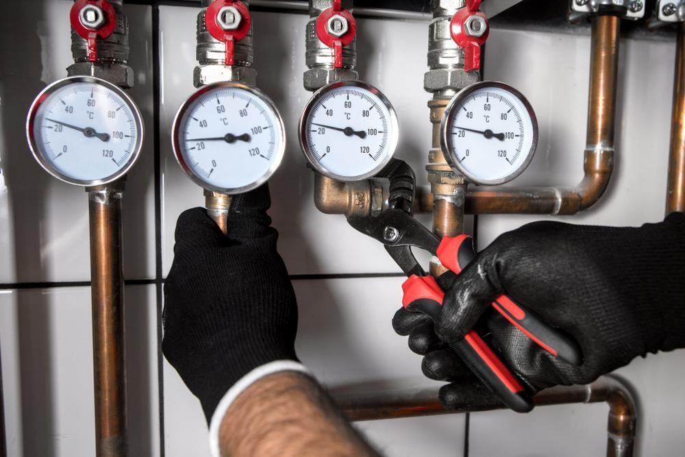 Plumber is Working on a Pipe With a Pair of Pliers — Approved Plumbing Service in Palmerston, NT