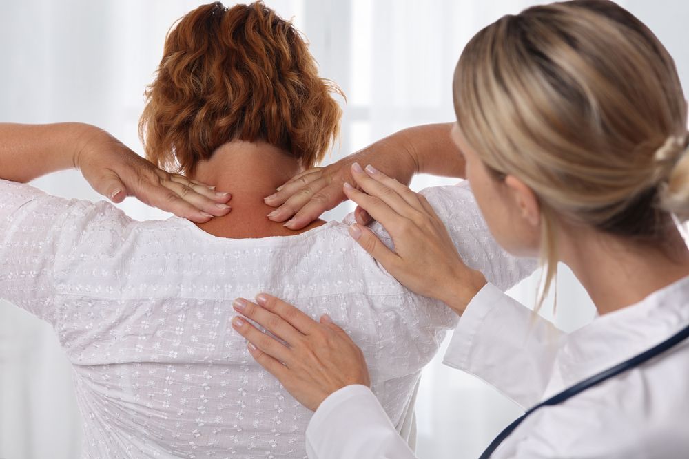 Woman's Neck And Back Being Examined By A Doctor
