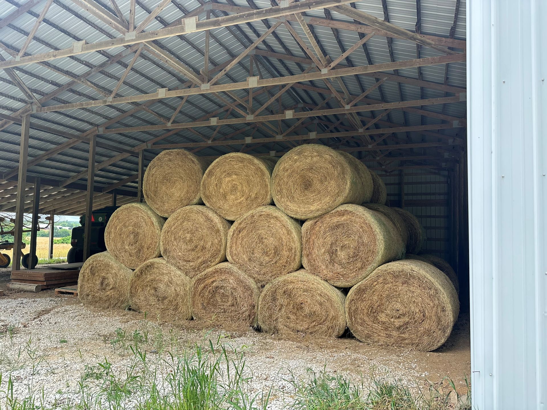Hay bales stacked inside a barn, brown and beige colors.