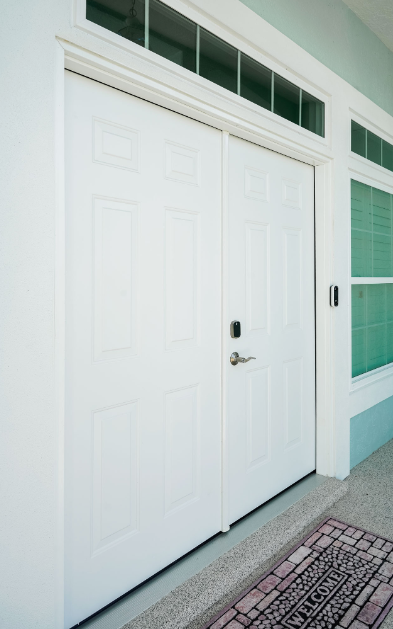 White double entry door with lock, sidelight, and transom windows.