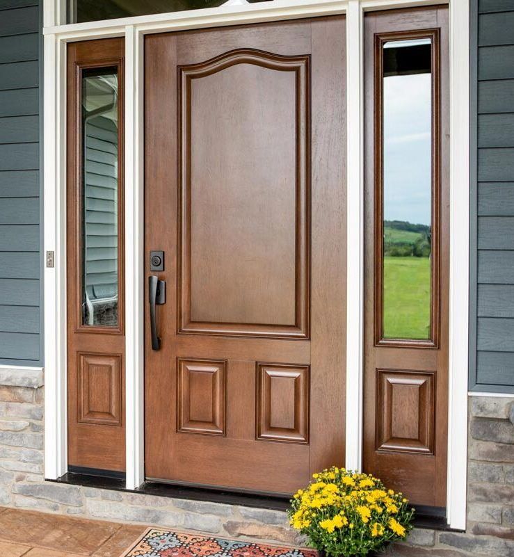 Brown front door with sidelights, flower pot on the stoop, exterior of a house.