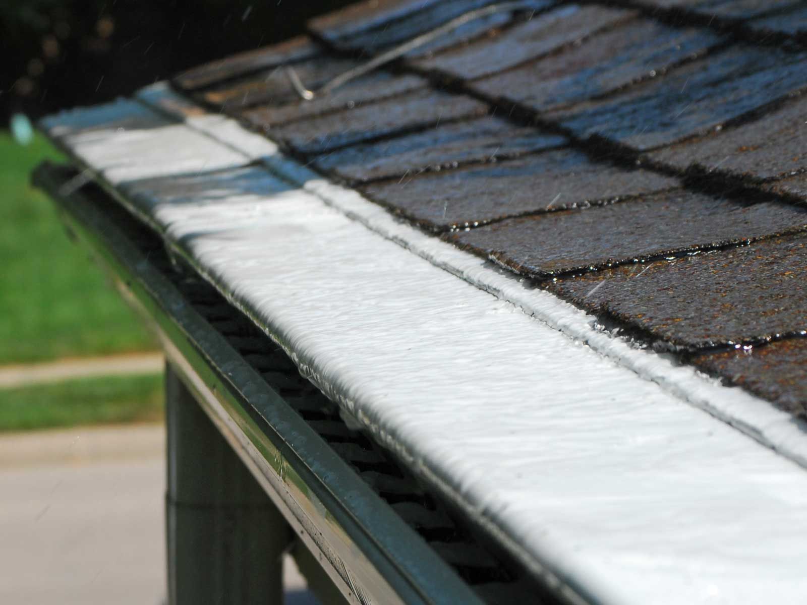 Roof gutter with ice buildup, partially blocking water flow.