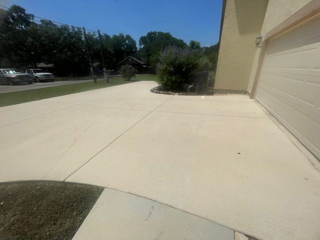 A driveway leading to a house with a white garage door in Spring Btanch