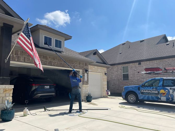 A man is cleaning a patio with a pressure washer.