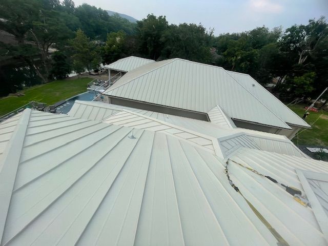 An aerial view of a house with a white metal roof