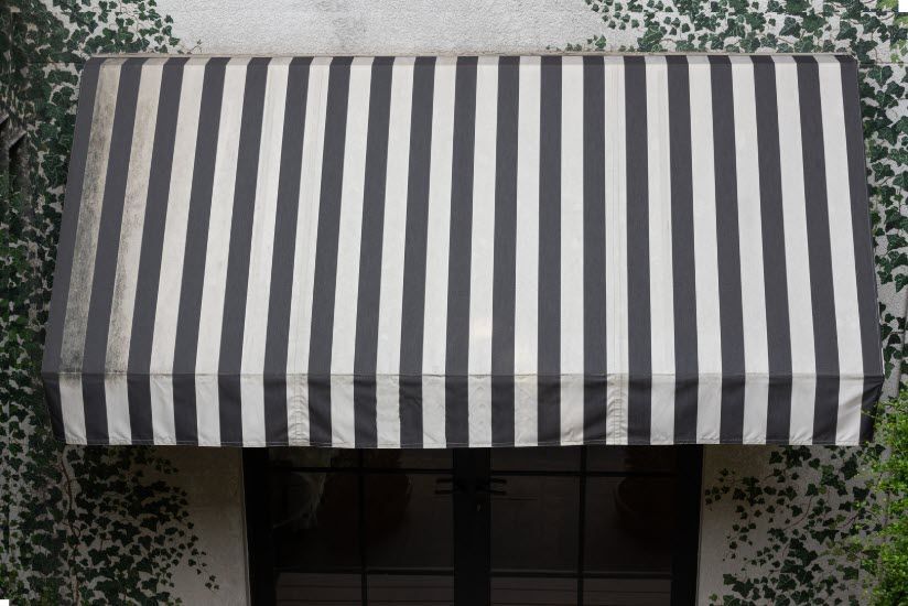 A black and white striped awning over a window