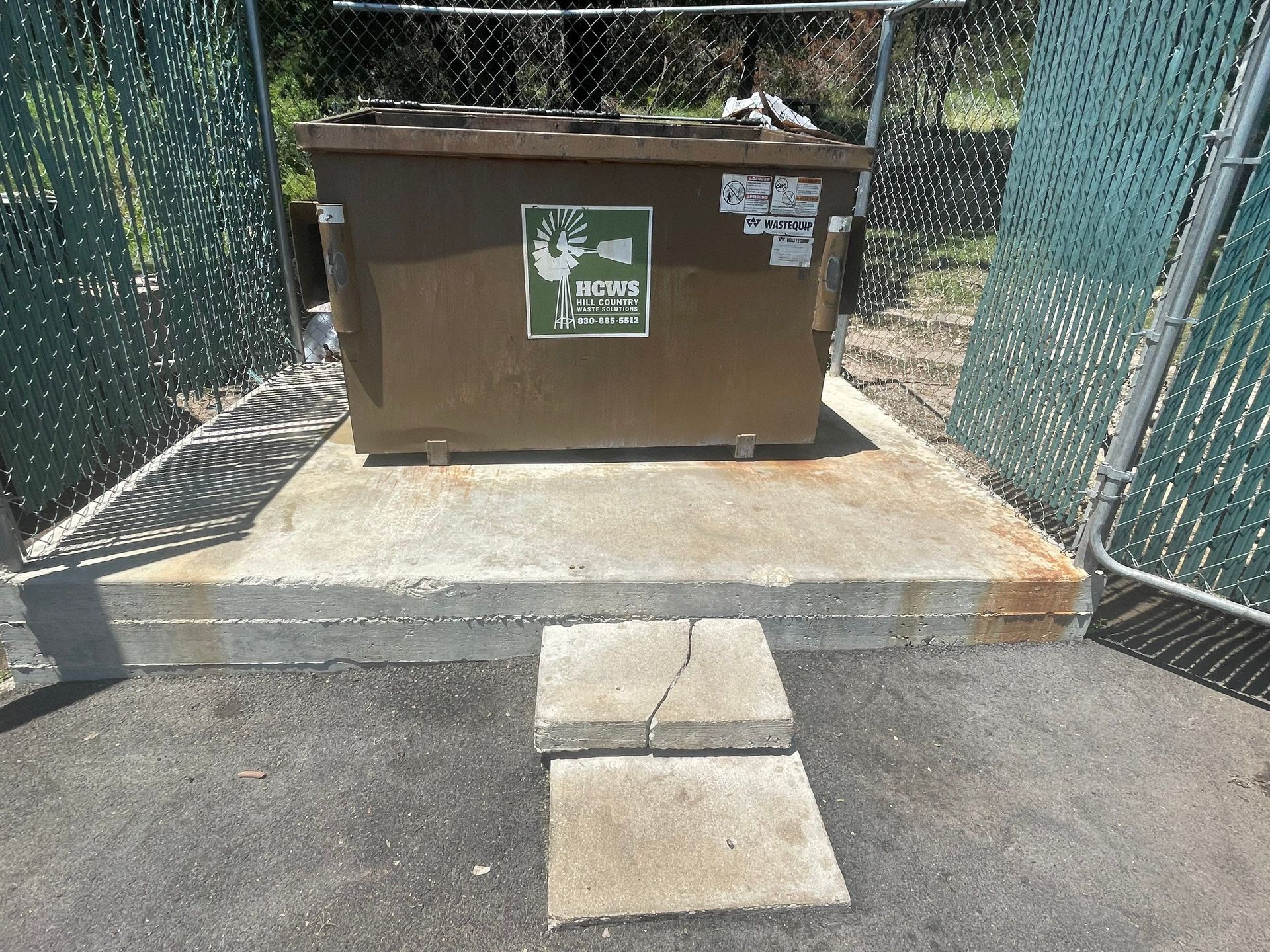 A brown dumpster with a green sticker on it that says missippi