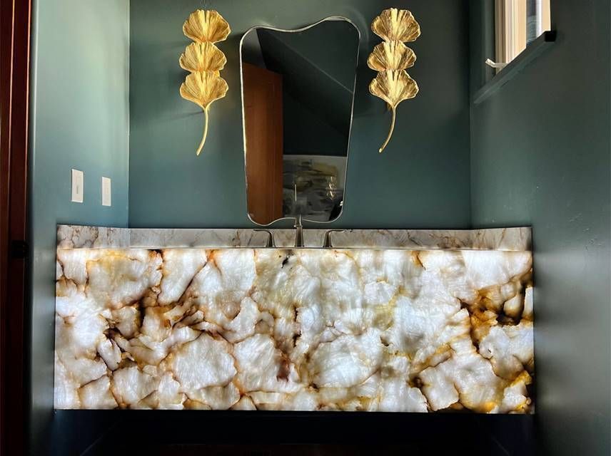Gold and white marble reception desk in a modern teal hallway with decorative wall art.