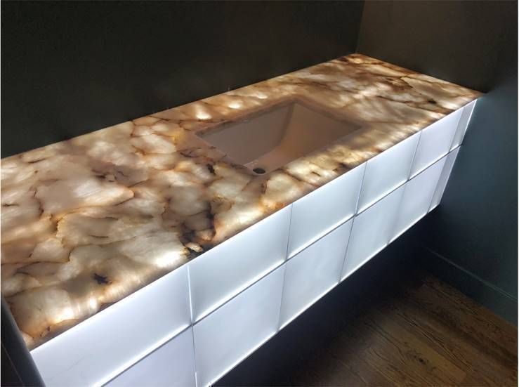 Modern bathroom vanity with glowing white drawers and a marbled countertop sink.