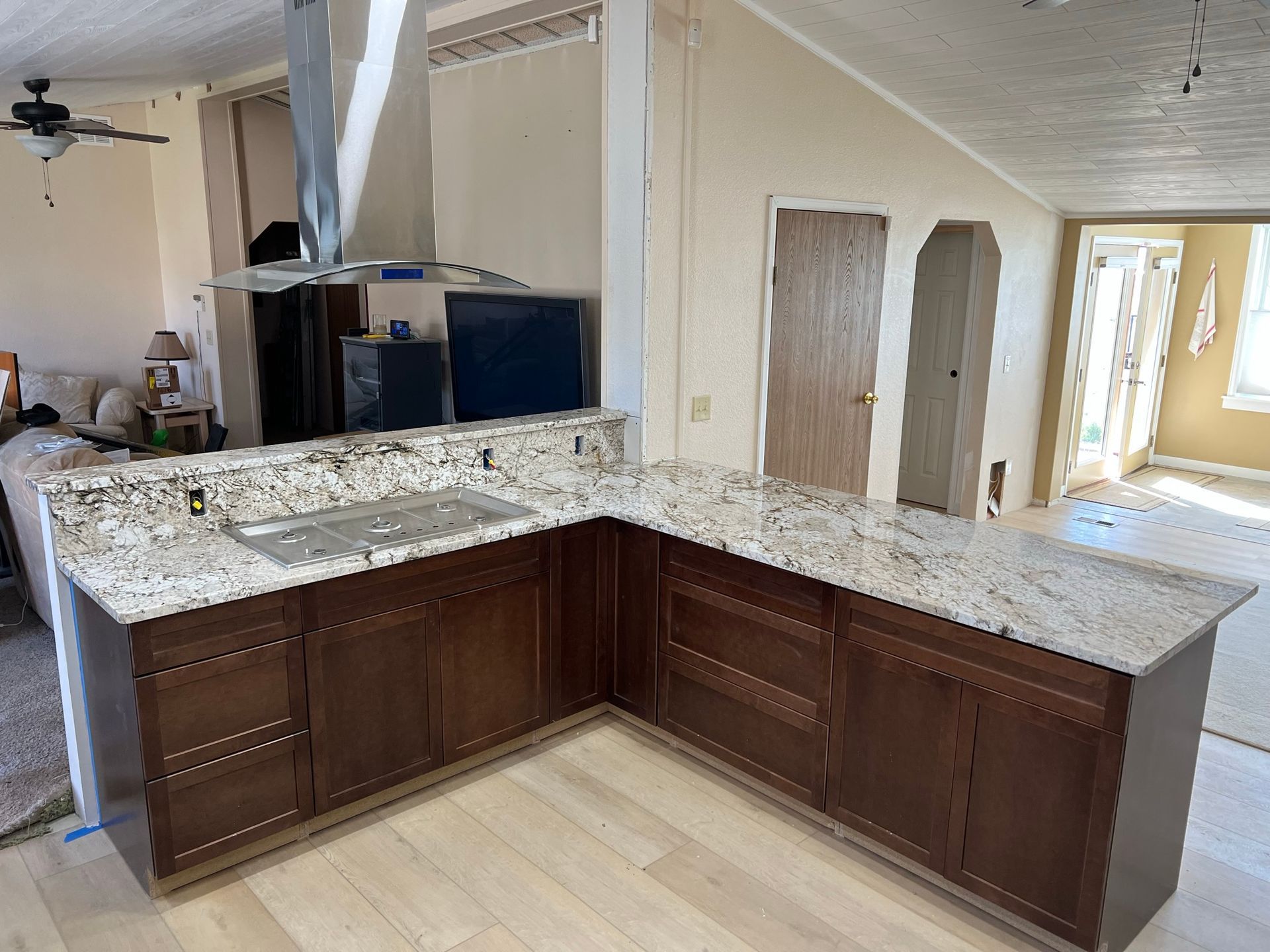 Empty kitchen with dark wood cabinets and granite countertops under construction