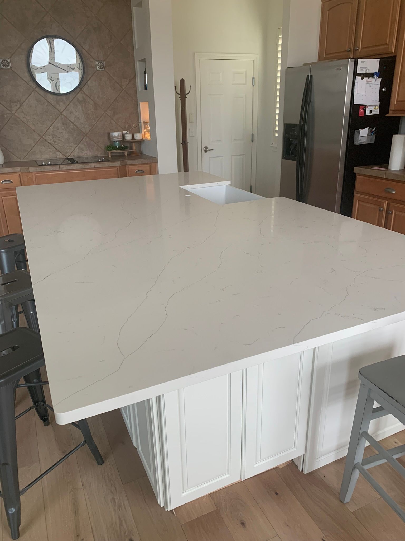 Kitchen with a large white island countertop and stools in a modern home interior