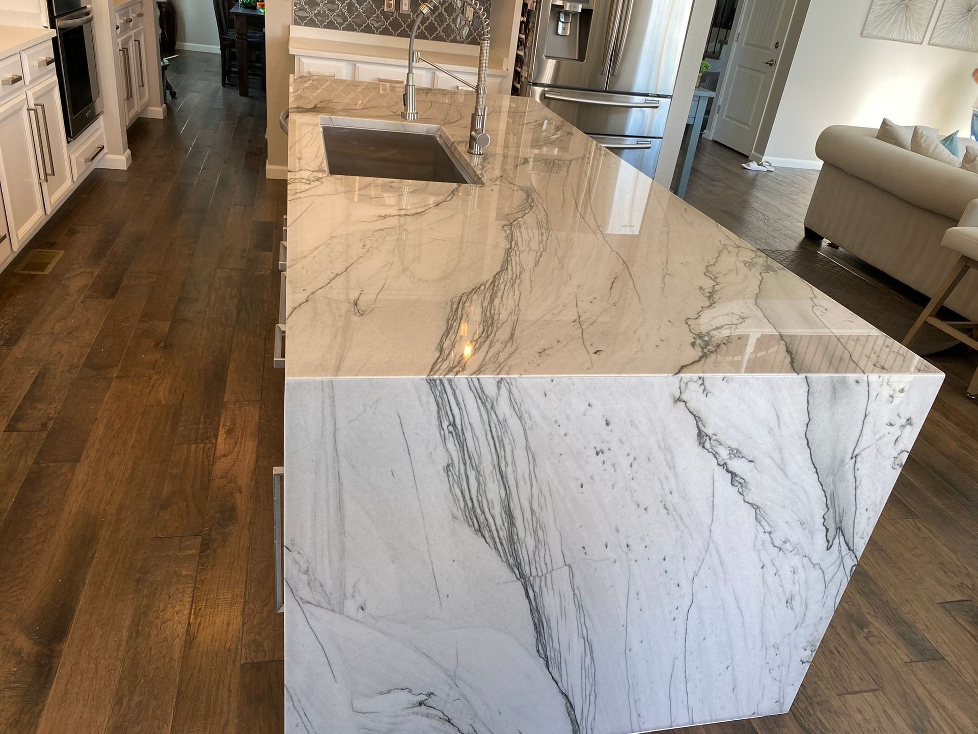 Modern kitchen with a marble island and dark wood floors