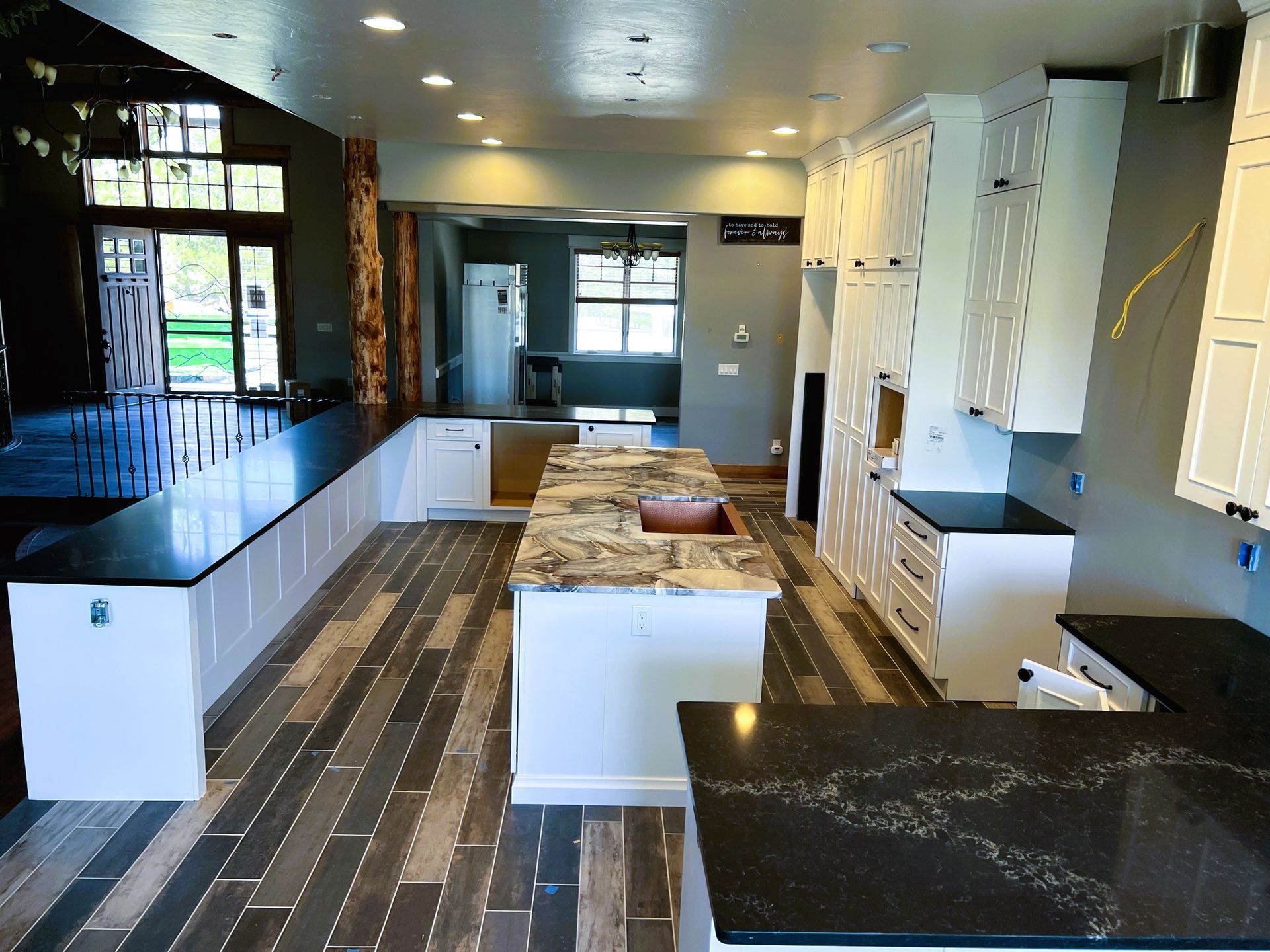 Modern kitchen with black countertops, white cabinets, and a central island with stools